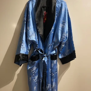 Morgonrock kimonomodell vändbar blå och svart - Säljer en fin morgonrock kimonomodell vändbar i blå och svart. Har själv köpt den begagnad därför är jag osäkert på storleken, men skulle gissa M/L.              Priset går att diskutera. 