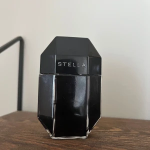 Svart parfymflaska Stella Mcartney Rose Absolute intense 30 ml (halva kvar) - Elegant svart parfymflaska från Stella med en geometrisk design. Flaskan har en stilren och modern look med en blank yta. Perfekt för den som gillar en sofistikerad och tidlös stil.