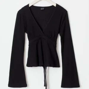 Svart långärmad topp från GinaTricot - Snygg svart långärmad topp från GinaTricot med v-ringning och knytband i midjan och bakifrån. 
