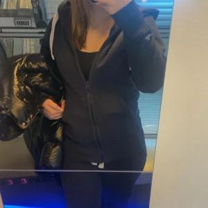 Mörkblå russemerch zip hoodie - Säljer en mörkblå zip hoodie från russemerch med dragkedja och huva. Den är populär och väldigt fin och skön, endast använd ungefär 3 gången. Dom vita banden har blivit lite färgade av tröjan i tvätten så dom är lite ljusblåa men det syns knappt(se sista bilden).