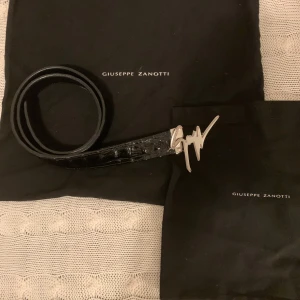 Svart bälte från Giuseppe Zanotti - Säljer mitt Giuseppe Zanotti bälte i krodokilskinn från Farfetch. Super snyggt att ha för att bära upp en simpel outfit ännu mer! Bältet är 105cm, men ifall det skulle vara för långt så kan extra hål göras simpelt. Dustbags och digitalt kvitto finns. Nypris 4490kr, Skick 8/10✅
