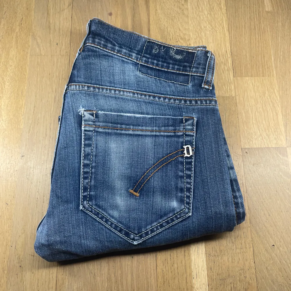 Snygga blå jeans från Dondup med en klassisk femficksdesign och slitna detaljer. De har en dragkedja och knapp framtill samt kontrastsömmar som ger en cool look. Perfekta för en avslappnad stil.. Farkut & Housut.