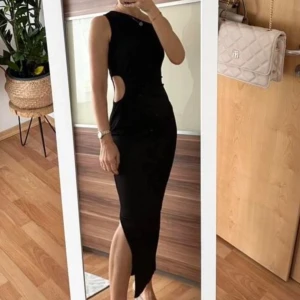 Svart klänning med cutout detalj på sidan -  Svart klänning med cutout detalj på sidan. Storlek S, normal i storlek.