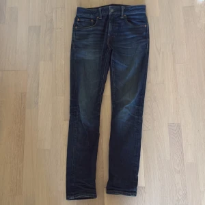 Mörkblå jeans från American Eagle - Säljer ett par snygga mörkblå jeans från American Eagle i modellen Flex. De har en klassisk femficksdesign och är i bra skick. Perfekta för både vardag och fest! 🕺