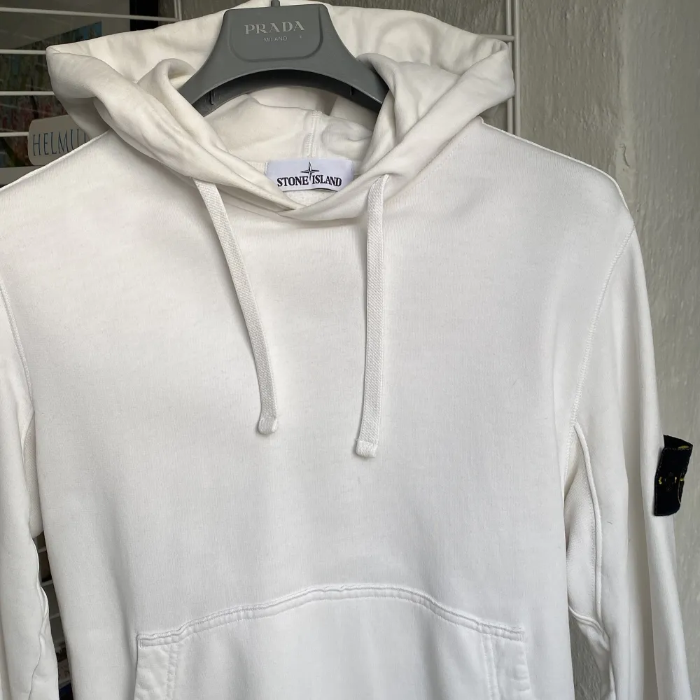 Säljer en stilren vit hoodie från Stone Island i mycket bra skick. Den har en klassisk känguruficka och justerbar huva med dragsko. . Tröjor & Koftor.