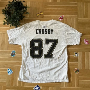 Sidney Crosby 87 Pittsburgh Penguins Vit NHL t-shirt med  - Säljer en vit Sidney Crosby NHL t-shirt från Reebok med Crosby 87 tryckt på ryggen.                                      ✅ Bra skick  📏 Storlek L  (stor i storleken) 📦 Snabb leverans    • Om du har några frågor, skicka gärna ett privat meddelande :)