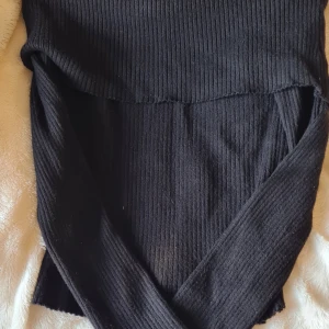 Svart ribbad tröja från H&M - Snygg svart ribbad tröja från H&M i storlek XS. Perfekt för både vardag och fest med sin stilrena design. Tröjan har en tight passform som framhäver figuren. Ett måste i garderoben för alla som älskar enkel och elegant stil.