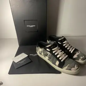 Säljer ett par snygga Saint Laurent sneakers i camou mönster (Light edition). Skorna är i 9/10 skick och saknar defekter. Strlk 42. Skriv för fler frågor och liknande