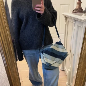 Jeansväska  - Snygg, unik axelväska i jeansmaterial med diagonala ränder i olika blå nyanser. Väskan har ett stort utrymme! Helt slutsåld! 