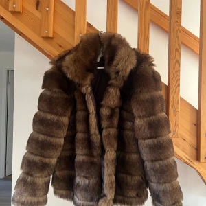 Brun pälsjacka - Tjejer säljer en supermjuk och fluffig brun pälsjacka som är perfekt för kalla vinterdagar. Jackan har en snygg passform och långa ärmar, vilket gör den både stilren och bekväm. Den är i ny skick (prislappen på) och redo att hålla dig varm och trendig hela säsongen❤️