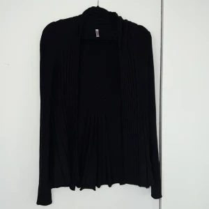 Svart ribbad kofta från Freequent - Säljer en stilren svart kofta från Freequent i storlek XS. Den är ribbad och har långa ärmar, perfekt för både vardag och fest. Koftan är i bra skick och passar utmärkt till höst- och vårsäsongen. 🖤