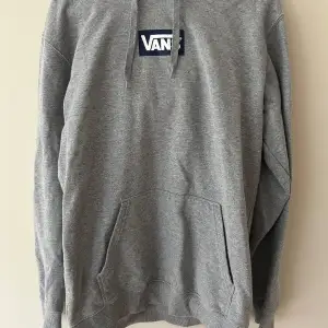 Säljer en grå hoodie från Vans i bra skick. Den har en klassisk design med en stor ficka fram och justerbar huva. Perfekt för en avslappnad stil och passar till det mesta. Skön och enkel att bära till vardags.