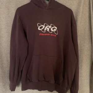 Brun hoodie från Jack & Jones - Säljer en brun hoodie från Jack & Jones med texten 'ORG Discover more' på framsidan. Den är i bra skick och perfekt för höst och vinter. Hoodien har en klassisk passform med långa ärmar och en stor ficka framtill. Superbekväm och stilren för vardagsbruk! Storlek s/m