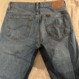 West jeans - lee  - Säljer ett par klassiska blå jeans från Lee i storlek W28 L32. De har en straight passform och är i mycket bra skick. Perfekta för vardagsbruk och kan matchas med nästan vad som helst. De har en traditionell femficksdesign och en bekväm midwaist.
