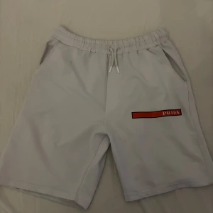 Prada shorts  - Säljer ett par stilrena vita shorts från Prada i storlek XL men de passar L och M. Kan diskutera priset! 