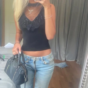 Svart spetsdetaljerad linne - Snygg svart topp med spetsdetaljer.