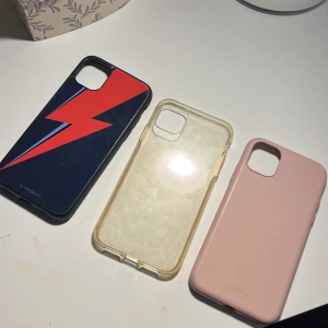 Mobilskal iPhone 11, 40 kr STYCK! - Säljer tre olika mobilskal! Det populära blixt skalet från Bjornberry som har tecken på användning men i bra skick, ett genomskinligt skal som är enkelt och jättefint, och ett supergulligt ljusrosa skal som är i jätte bra skick men kan ha något tecken på användning. 