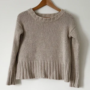 Beige stickad tröja - Säljer en mysig beige stickad tröja med ribbade detaljer vid hals, ärmslut och nederkant. Perfekt för kyliga dagar och ger en stilren look. Passar bra till både jeans och kjol. 🧶Storlek M (S).