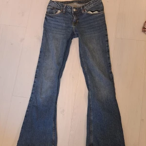 bootcut jeans med rosett - Snygga lågmidjade bootcut jeans med rosetter på bakfickorna. Inga synliga defekter! Innerbenslängd: 75cm  Midjemått raktöver: 36cm      Kontakta för frågor! 💕