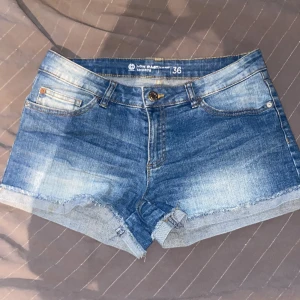 Blå jeansshorts från Denim -  Blåa låg midjade jeans shorts storlek 36. Säljer på grund av att de är för stora för mig. använd några gånger men det syns knappt. 