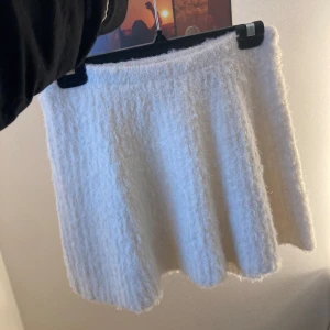Vit fluffig kjol från H&M - Mysig vit fluffig kjol från H&M i en kort modell. Kjolen har en mjuk och lurvig textur som ger en unik look. Perfekt för att hålla sig varm och stilren under kyligare dagar. Använd en gång helt nytt skick. 