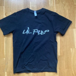 Svart t-shirt med Lil Peep-tryck Small  - Säljer en svart t-shirt med ett stilrent Lil Peep-tryck på framsidan. T-shirten är kortärmad och gjord i ett mjukt material som känns skönt mot huden. Perfekt för fans av Lil Peep eller för dig som gillar en cool och avslappnad stil.