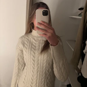 Beige stickad tröja från Amisu - Säljer en mysig beige stickad tröja från Amisu. Tröjan har ett klassiskt flätmönster och en hög krage som håller dig varm. Perfekt för kyliga dagar. Passar bra till jeans eller kjol. 🧶✨Säljer då den inte används. 