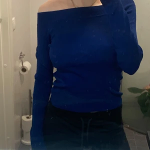 Blå offshoulder tröja - Snygg blå offshoulder tröja med långa ärmar. Perfekt för en stilren look. Tröjan har en tight passform som framhäver figuren. Aldrig använd🤍🤍 Passar XS/S