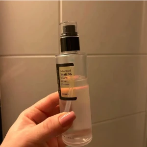 COSRX Advanced Snail 96 Mucin Power Essence - En återfuktande essence från COSRX med 96% snigelsekretfiltrat. Perfekt för att ge huden en fuktboost och förbättra hudens elasticitet. Kommer i en genomskinlig flaska med pump för enkel applicering.
