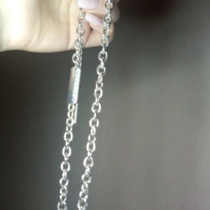 Silverfärgat halsband med kedja - Stilrent silverfärgat halsband med kedjedesign. Halsbandet har en rektangulär platta med ingraverade diamanter! Den är ca 0,7 mm tjock. 🤍