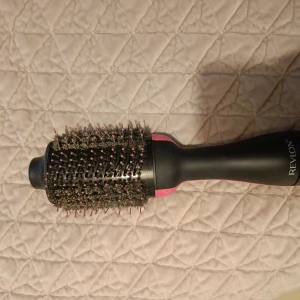 Revlon hårborste med rund borste - Säljer en Revlon hårborste med rund borste och svarta borst med rosa toppar. Perfekt för att skapa volym och styling. Ergonomiskt handtag för bekväm användning. Varan är använd men går att rengöra, av den anledningen säljer jag den billigt. Kan diskutera priset!