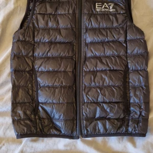 Svart dunväst från Emporio Armani - Snygg svart dunväst från Emporio Armani med dragkedja framtill. Den är äkta såklart, knappt använd. Hör av dig i pm om de är några frågor.