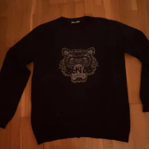 Svart tröja med tigertryck - Säljer en svart tröja med ett coolt tigertryck på framsidan. Tröjan har långa ärmar och en rund halsringning. Perfekt för en avslappnad stil.