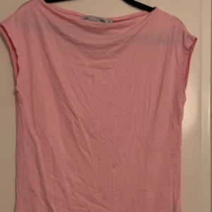 Rosa topp från lager 157 - Säljer en enkel och stilren rosa topp från lager 157. Toppen har en lös passform och är ärmlös, perfekt för varma dagar. Den är tillverkad i ett mjukt material som känns skönt mot huden.