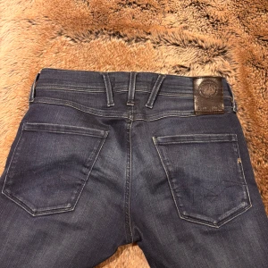 Replay anbass hyperflex jeans  - Säljer ett par mörkblå Replay Hyperflex Anbass jeans. De har en slim passform och är tillverkade i stretchigt material för extra komfort. Säljer för mycket bra pris🙌🏼Säljer pga att jeansen har blivit för små. 