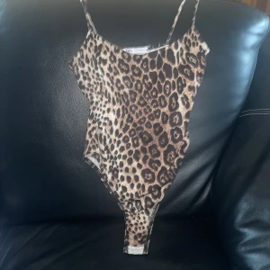 Leopardmönstrad bodysuit från Zara - Säljer en snygg leopardmönstrad bodysuit från Zara i storlek XS. Den har smala axelband och är perfekt för en utekväll eller fest. Materialet är mjukt och stretchigt för en bekväm passform. Bodyn har knäppning i grenen för enkel på- och avtagning. Säljer för 200 då den e slutsåld 