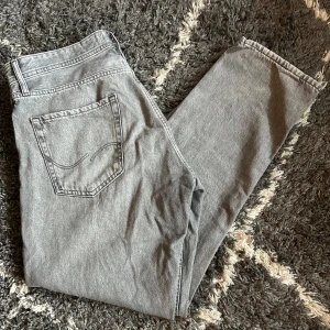Jack and Jones jeans  - Säljer ett par grå jeans i loose fit. De har en klassisk femficksdesign och är perfekta för en avslappnad stil. Passar bra till både vardag och fest. Skicket är mycket bra och de är bekväma att bära.