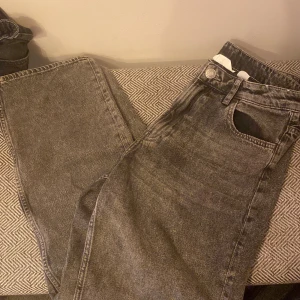 Grå jeans i storlek 164 - Säljer ett par grå jeans i storlek 164. De har en klassisk design med fem fickor och knappgylf. Perfekta för vardagsbruk och passar till det mesta. Skicket är bra och de är bekväma att ha på sig. Perfekt för dig som vill ha en stilren look!