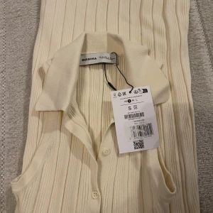 Klänning  - Helt oanvänd bege klänning Sitter tight men är stretchig  Öppen vid ryggen  Har knappar under brösten och en slits i mitten av klänningen