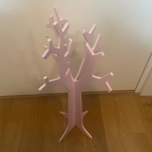 Rosa smyckesträd - Säljer ett supergulligt rosa smyckesträd i träform. Perfekt för att hänga upp dina favoritarmband, halsband och ringar. Trädet har flera grenar för att organisera dina smycken snyggt och prydligt. Passar perfekt i sovrummet eller på sminkbordet. 🌸