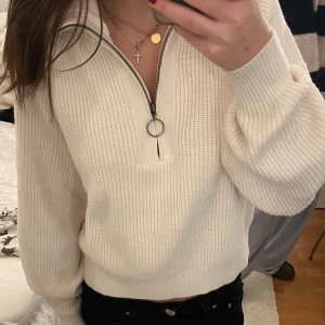 Stickad tröja med dragkedja - Jättefint skick. Använd fåtal gånger. Superskönt material. Tröjan är lite åt det krämvita hållet. Skriv om det är något du undrar💕