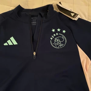 Ajax träningströja långärmad zip - Aldrig använd i nyskick med tagsen kvar. Slutsåld på adidas nypris runt 1000. Storlek xs. Skriv vid funderingar