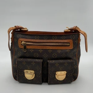 Louis Vuitton Hudson - Louis Vuitton Monogram Hudson Gm Shoulder Bag  Skick: C/D, väldigt fint vintage skick. Bakre hörnen som är skadade men syns inte lika mycket när väskan bärs enligt oss. Se alltid bilder för egen uppfattning.  Serienummer: VI0046  Sku: V012  Mått: B30
