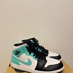 Nike Air Jordans i svart, vit och turkos - Säljer ett par snygga Nike Air Jordans i svart, vit och turkos. Skorna är i nytt skick och har en cool design med snörning. Perfekta för både vardag och fest! 🖤🤍💙