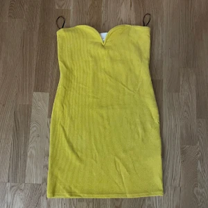 Gul klänning  - Säljer en gul ribbad klänning från H&M. Den är axelbandslös och klänningen är i nyskick och har en tight passform som framhäver figuren. 🌼