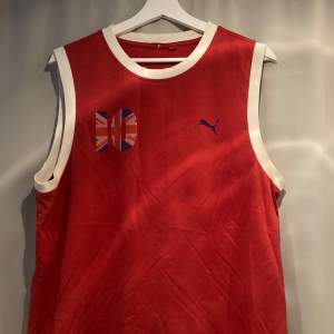 Ett linne/tank-top från Puma med ett ”Great Britain” tryck. Storleken på tvätt lappen är large men passar någonstans mellan en medium och en large enligt mig 🤓Perfekt blokecore tröja för Oasis återföreningen 2025!