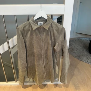 Beige mockajacka från ciszere  - Säljer en snygg beige mockajacka från cidzere. Jackan har en dragkedja framtill och en klassisk krage. Perfekt för höst och vår, och den har en stilren look som passar både till vardags och fest. Jackan är i mycket bra skick och har långa ärmar.