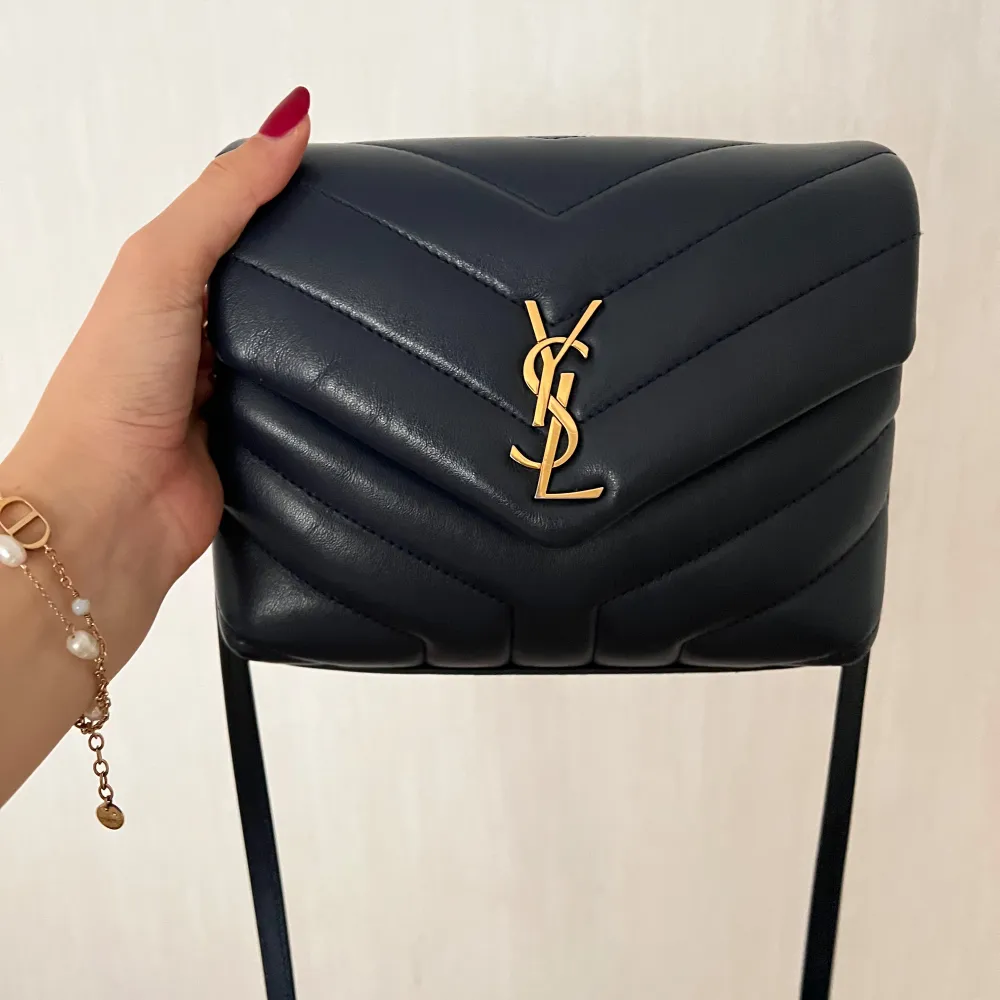 Säljer min otroliga loulou toy bag i en blå färg som inte finns att köpa längre. Köpt ifrån deras butik. Köptes 2022 och kvitto finns. Köptes för 16000kr. Den lilla slitning som finns syns på 3:e bilden . Laukut & Käsilaukut.