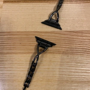 Svart armband till Apple Watch  - Snyggt svart armband med unika kedjedetaljer och en cool design. Armbandet har en stilren och modern look, perfekt för att ge din outfit en extra edge. Detta är till Apple Watch och säljes pga det inte är min stil. 