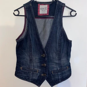 Jeansväst - Använd fåtal ggr. Bra skick. Figursydd passform. Mer grå och marinblå irl